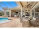 Covered patio featuring ample seating, an outdoor dining area, and stunning pool views at 19107 Avenue Bayonnes, Lutz, FL 33558