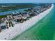 A stunning aerial view of beachfront condos along a picturesque shoreline with sparkling turquoise waters at 19530 Gulf Blvd # 4A, Indian Shores, FL 33785