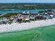 Expansive aerial showcasing condos along a beautiful beach with turquoise waters and lush greenery at 19530 Gulf Blvd # 4A, Indian Shores, FL 33785