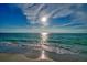 Waves gently lapping onto the sandy beach on a sunny day with sparkling sun reflecting on the water at 19530 Gulf Blvd # 4A, Indian Shores, FL 33785