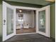 A sunroom, featuring large glass doors, with two comfy chairs and a window at 19530 Gulf Blvd # 4A, Indian Shores, FL 33785