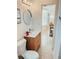 Bathroom with modern vanity, mirror, and toilet; light and airy ambiance with an adjacent room visible at 1980 Forked Creek Dr, Englewood, FL 34223