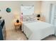 Bedroom featuring a queen-sized bed, stylish decor, and a light and airy ambiance from natural light at 1980 Forked Creek Dr, Englewood, FL 34223