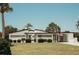 Charming single-story home with a well-manicured lawn, palm trees, and an American flag at 1980 Forked Creek Dr, Englewood, FL 34223