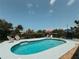 The backyard pool is surrounded by lush landscaping and comfortable seating areas for relaxing at 1980 Forked Creek Dr, Englewood, FL 34223