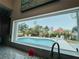 Indoor view of a pool and canal through a large window above the kitchen sink at 1980 Forked Creek Dr, Englewood, FL 34223