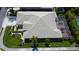 An aerial view of a property featuring a neutral tile roof, screened-in patio, and landscaped garden at 2220 Elizabeth Way, Dunedin, FL 34698