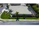A well manicured lawn surrounds this house, featuring an expansive roof and screened-in patio at 2220 Elizabeth Way, Dunedin, FL 34698