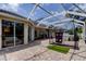 Screened patio with paver stones, golf net, and sliding glass doors to the home create a serene living space at 2220 Elizabeth Way, Dunedin, FL 34698