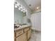Bright bathroom featuring granite counters, wooden cabinets, and modern vanity lighting at 2220 Elizabeth Way, Dunedin, FL 34698