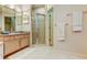 Bathroom featuring a granite countertop vanity, glass enclosed shower and white tile floor at 2220 Elizabeth Way, Dunedin, FL 34698