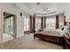 Spacious bedroom with a four-poster bed, tray ceiling, and expansive windows overlooking the lanai at 2220 Elizabeth Way, Dunedin, FL 34698