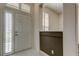 Bright foyer with white tile flooring, half wall, transom window, and white front door creating a welcoming entryway at 2220 Elizabeth Way, Dunedin, FL 34698