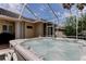 Backyard hot tub set on a brick patio with a screened enclosure for year-round enjoyment at 2220 Elizabeth Way, Dunedin, FL 34698