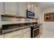 Charming kitchen with stainless appliances, updated tile backsplash, and ample cabinet space at 2220 Elizabeth Way, Dunedin, FL 34698