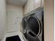 Laundry room featuring front load washer and dryer, storage cabinets, and tile flooring at 2220 Elizabeth Way, Dunedin, FL 34698