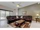 Comfortable living room showcasing a luxurious, oversized leather sectional sofa and neutral-toned décor at 2220 Elizabeth Way, Dunedin, FL 34698