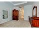 Spacious main bedroom featuring an elegant armoire, dresser and neutral carpet at 2220 Elizabeth Way, Dunedin, FL 34698