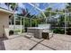 Outdoor patio with brick flooring features a luxurious spa and seating area, perfect for relaxation at 2220 Elizabeth Way, Dunedin, FL 34698