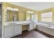 Bright bathroom features a double sink vanity with large mirror and a separate bathtub at 27012 Sea Breeze Way, Wesley Chapel, FL 33544
