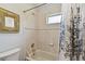 Cozy bathroom with neutral tile, framed mirror, bathtub, and shower with decorative curtain at 27012 Sea Breeze Way, Wesley Chapel, FL 33544