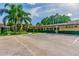 Front view of a clubhouse with parking, landscaping, and shaded picnic areas on a sunny day at 27012 Sea Breeze Way, Wesley Chapel, FL 33544