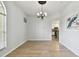 Dining room with modern chandelier, wood floors, and access to kitchen at 27012 Sea Breeze Way, Wesley Chapel, FL 33544