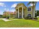 Inviting front exterior with large pillars, well-manicured lawn, and a decorative water fountain feature at 27012 Sea Breeze Way, Wesley Chapel, FL 33544