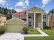 Beautiful two-story home with large columns, red roof, manicured lawn, and attached garage at 27012 Sea Breeze Way, Wesley Chapel, FL 33544