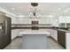 Bright kitchen features stainless steel appliances, a center island, and modern chandelier lighting at 27012 Sea Breeze Way, Wesley Chapel, FL 33544