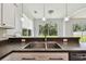 Kitchen sink with stainless faucet and a view of the trees in the backyard through large sliding glass doors at 27012 Sea Breeze Way, Wesley Chapel, FL 33544