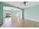 Spacious open living area with light-colored wood flooring and a ceiling fan at 27012 Sea Breeze Way, Wesley Chapel, FL 33544