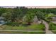 Aerial view of a yellow brick home with a manicured lawn, mature trees, and sunset skies at 2769 St Andrews Blvd, Tarpon Springs, FL 34688