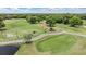 Aerial view of a golf course with practice area, mature trees, and ponds at 2769 St Andrews Blvd, Tarpon Springs, FL 34688