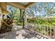 Covered porch with a brick floor, white railings, and views of the lush, landscaped backyard at 2769 St Andrews Blvd, Tarpon Springs, FL 34688