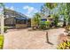 Charming backyard showcases brick pavers, a fountain, manicured landscaping, and a screened pool enclosure at 2769 St Andrews Blvd, Tarpon Springs, FL 34688