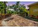 Beautiful backyard featuring a brick pathway, a white gazebo, lush landscaping, and mature trees at 2769 St Andrews Blvd, Tarpon Springs, FL 34688