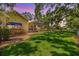 Manicured backyard has lush green lawn, brick pathway, and screened-in pool area, perfect for relaxation and entertainment at 2769 St Andrews Blvd, Tarpon Springs, FL 34688