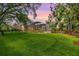 Expansive backyard with a screened-in patio, well-maintained lawn, and beautiful landscaping at 2769 St Andrews Blvd, Tarpon Springs, FL 34688