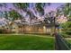 Backyard showcases a lush lawn, mature trees, colorful landscaping, and a screened pool area for ultimate relaxation at 2769 St Andrews Blvd, Tarpon Springs, FL 34688