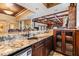 Granite countertop bar with a sink, mini refrigerator and wood cabinets at 2769 St Andrews Blvd, Tarpon Springs, FL 34688