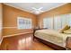 Cozy bedroom with hardwood floors, tan walls, a queen bed, and shuttered window at 2769 St Andrews Blvd, Tarpon Springs, FL 34688