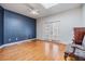 Bedroom with hardwood flooring, blue accent wall, and french doors at 2769 St Andrews Blvd, Tarpon Springs, FL 34688