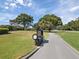 Entrance to golf community with a clock on a manicured and landscaped circular drive on a sunny day at 2769 St Andrews Blvd, Tarpon Springs, FL 34688