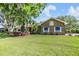 Charming brick house with blue awnings, surrounded by a green lawn and mature landscaping at 2769 St Andrews Blvd, Tarpon Springs, FL 34688