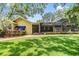 Well-maintained home exterior has a screened pool, lush lawn, and mature trees, providing a serene backyard retreat at 2769 St Andrews Blvd, Tarpon Springs, FL 34688