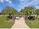 Brick paved outdoor fire pit area surrounded by Adirondack chairs and lush landscaping at 2769 St Andrews Blvd, Tarpon Springs, FL 34688