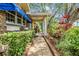 Charming brick home exterior with a blue awning, brick walkway, and lush, colorful landscaping at 2769 St Andrews Blvd, Tarpon Springs, FL 34688