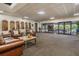 Lounge area with comfortable seating, awards wall, and sliding glass doors leading to an outdoor patio at 2769 St Andrews Blvd, Tarpon Springs, FL 34688