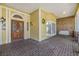 Welcoming covered front porch with brick flooring, columns, and a charming porch swing at 2769 St Andrews Blvd, Tarpon Springs, FL 34688